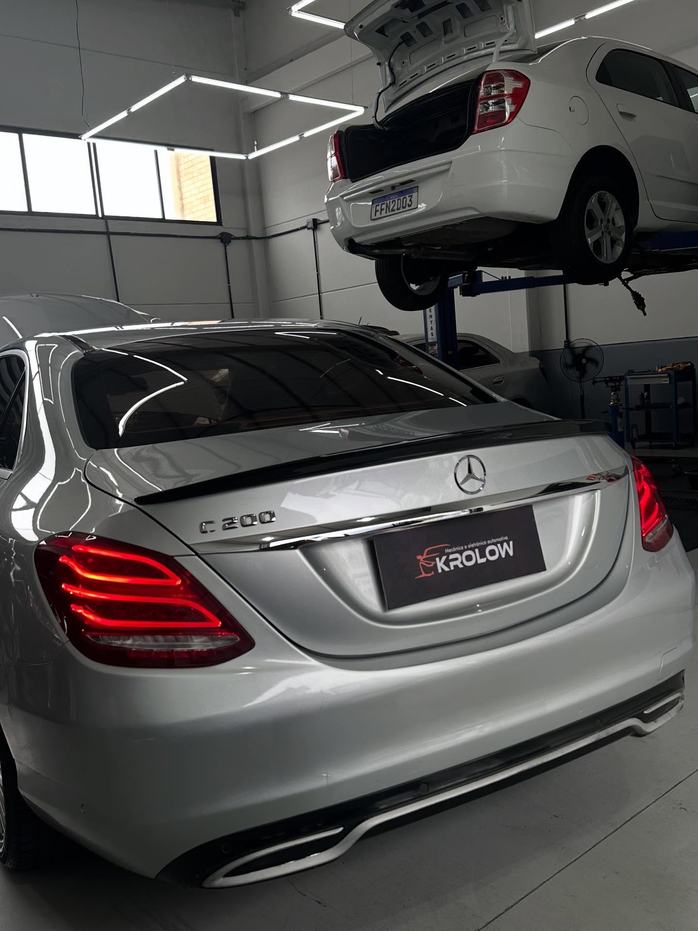 Mercedes-Benz C200 em manutenção na oficina Krolow, com veículo no elevador ao fundo